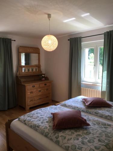 a bedroom with two beds and a dresser and a mirror at Schweizer Häusl in Bayerisch Eisenstein