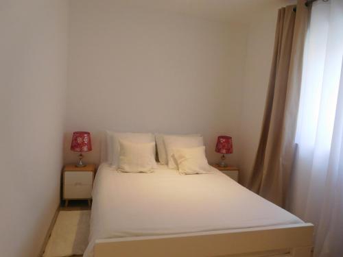a bedroom with a white bed with two lamps at Villa Aronija in Kotor