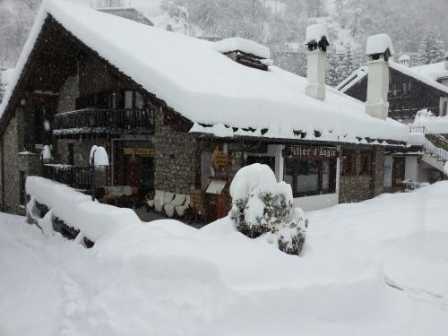 a house covered in snow in front at Hotel Pilier D'Angle & Wellness in Courmayeur