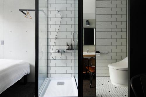a bathroom with a shower with a toilet and a sink at HOTEL CEN in Tokyo