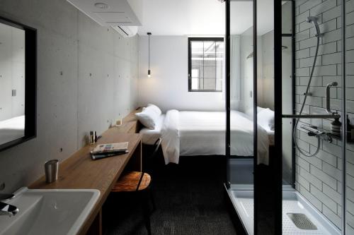 a bedroom with a bed and a sink and a tub at HOTEL CEN in Tokyo