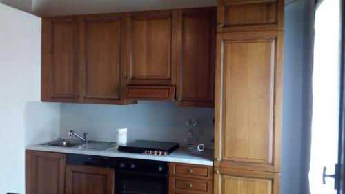 a kitchen with wooden cabinets and a stove at Villa Panoramica in Lavena Ponte Tresa
