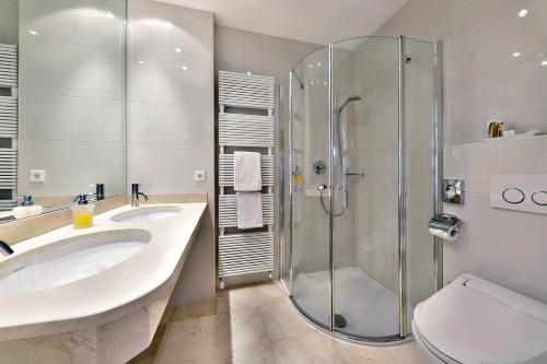 a bathroom with a shower and a sink and a toilet at Hotel Mühle Mayer in Termeno