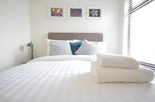 a white bed with two towels on top of it at Lexicon House - 4 bedrooms 3 bathrooms in Stoke on Trent