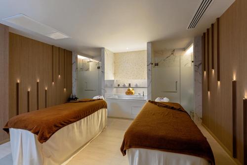 a room with two beds and a bathroom at The Nature Phuket - SHA Extra Plus in Patong Beach