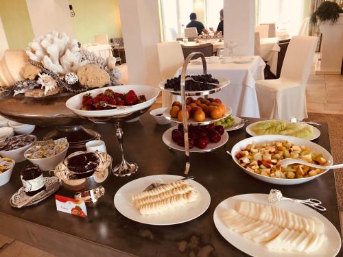 una mesa con muchos platos de comida. en Hotel Villa Seeschau - Adults only, en Meersburg
