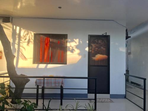 a wall with two paintings and a door and a tree at Paguia’s Cottages in Mambajao