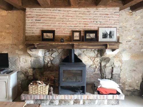 a stone wall with a stove in a room at Côte du Jardin in Pouillé