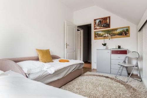 a bedroom with a couch and a sink in it at Luca Holiday House in Budaörs