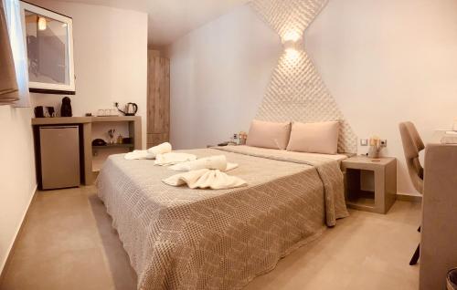 a bedroom with a large bed with two towels on it at Aeris in Koufonisia
