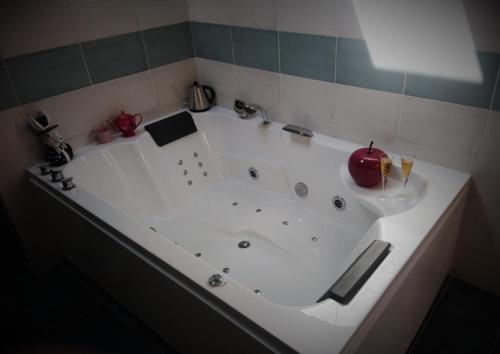 una gran bañera blanca con una manzana. en EpicuRooms - Maison d'Hôtes Romantique - Chambres à thème, en Gallargues-le-Montueux