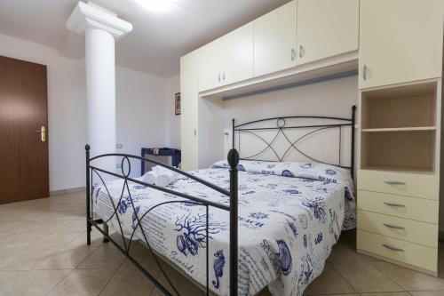 ドームス・デ・マリーアにあるHouse & Sea Chiaのベッドルーム1室(青と白の掛け布団付きのベッド1台付)