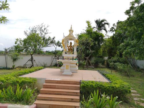 a monument in the middle of a garden at Sirapa Resident in Chachoengsao