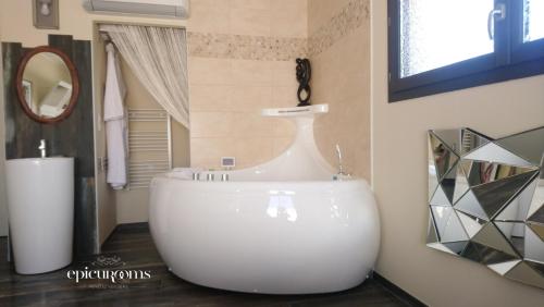 a white tub in a bathroom with a mirror at Plgfe - Maison d'hôtes EPICUROOMS - Suites romantiques 5 étoiles in Gallargues-Le-Montueux