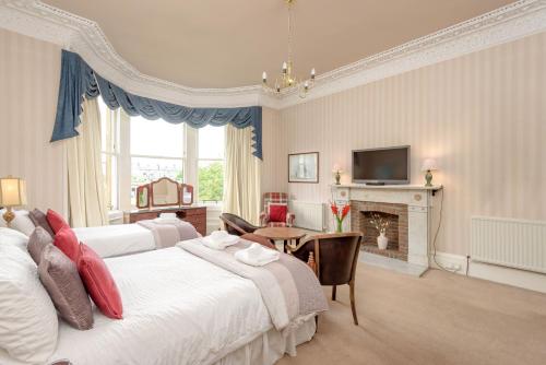 a bedroom with two beds and a table and a television at No 45 in Edinburgh
