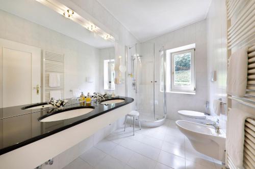 a bathroom with two sinks and a shower at Hotel Mühle Mayer in Termeno