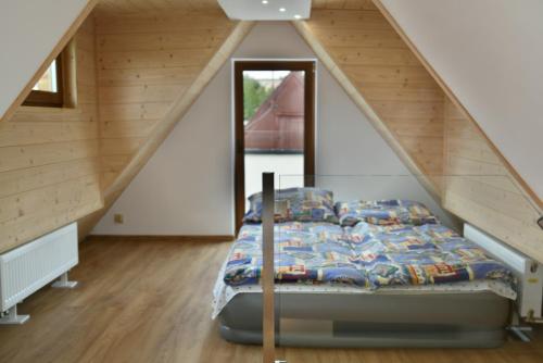 a bed in the attic of a house at Domek - Apartament Marynarski z Kominkiem in Ustka
