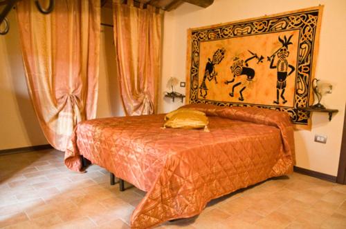 a bedroom with a bed with a painting on the wall at Agriturismo Villa Rancio in Passignano sul Trasimeno