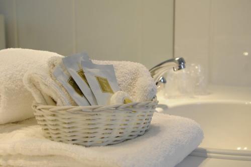 a basket of towels and a sink in a bathroom at Hotel Limburgia in Kanne