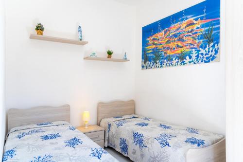 een slaapkamer met 2 bedden en een schilderij aan de muur bij Villino La Fontanella in Portoferraio