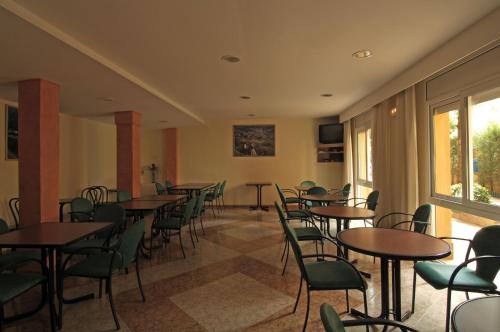 a room with tables and chairs and a window at Fonda Finet in Sant Feliu de Pallerols
