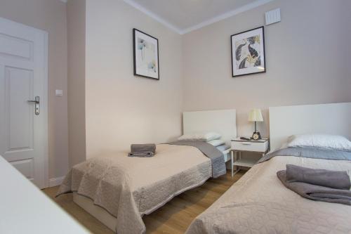 sypialnia z 2 łóżkami i stołem z lampką w obiekcie CR Apartament przy Rynku Sienkiewicza 6 w mieście Białystok