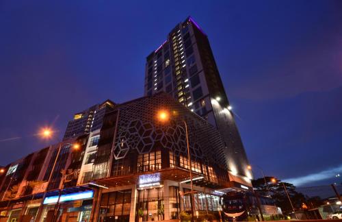 a tall building at night with at Mercure Selangor Selayang in Batu Caves