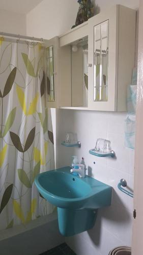 baño con lavabo azul y cortina de ducha en Tini Apartman, en Balatonfüred