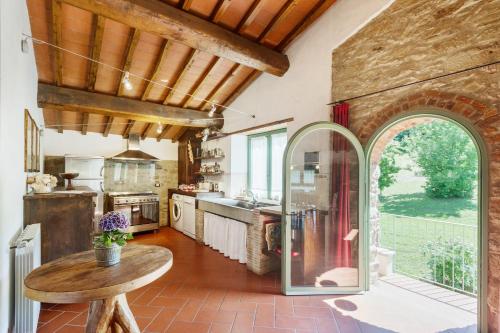 a large kitchen with a table and a large window at Resort con vista nel Chianti Rufina in Londa