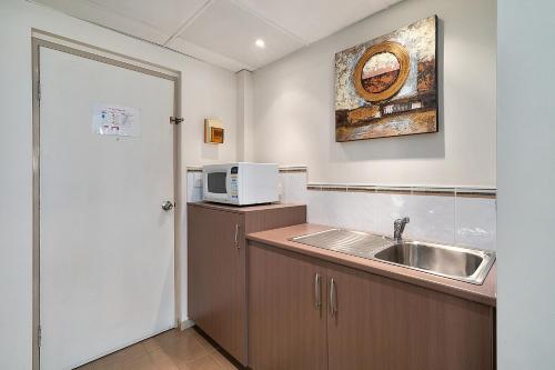 cocina con fregadero y microondas en Comfort Inn Heritage Wagga, en Wagga Wagga