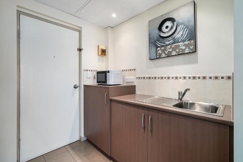 a kitchen with a sink and a microwave at Comfort Inn Heritage Wagga in Wagga Wagga