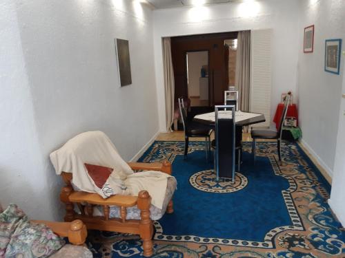 a living room with a table and chairs on a blue rug at CASA DI MARCO in Antwerp