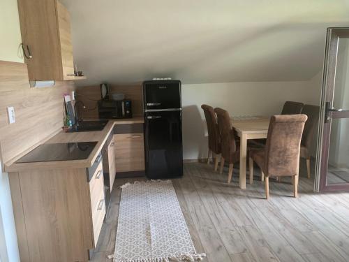 a kitchen with a refrigerator and a table with chairs at Apartmánový dom Magda in Vrbov