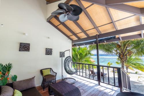 a living room with a balcony with a view of the beach at Serenity Villas Rarotonga in Rarotonga