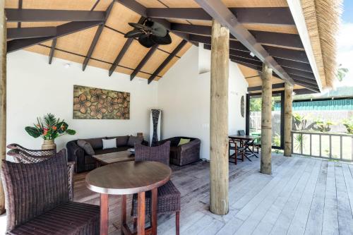 a living room with a table and chairs at Serenity Villas Rarotonga in Rarotonga