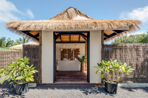 a small house with a thatched roof at Serenity Villas Rarotonga in Rarotonga