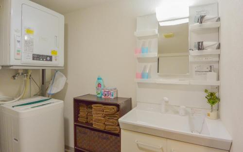 a small bathroom with a sink and a toilet at KIYAZA Home Sapporo in Sapporo
