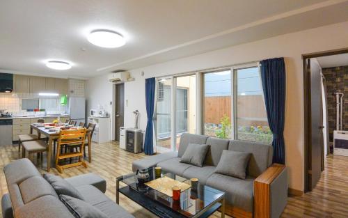 a living room with two couches and a kitchen at KIYAZA Home Sapporo in Sapporo