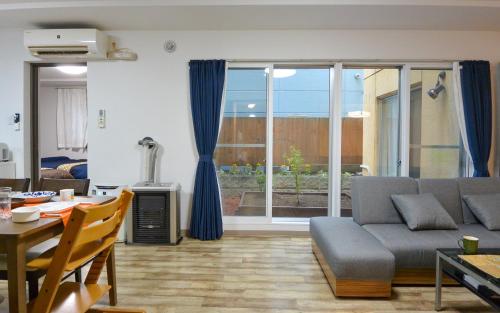 a living room with a couch and a table at KIYAZA Home Sapporo in Sapporo