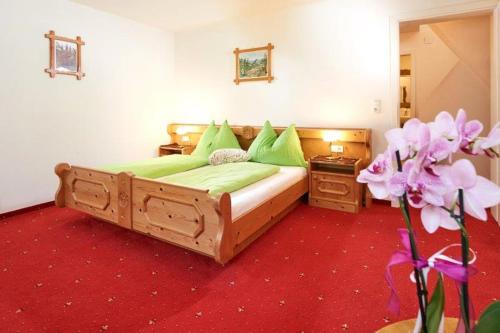 a bedroom with a bed with green pillows and a flower at Appartement Königslehen in Radstadt