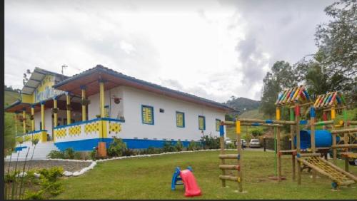 a house with a playground in the yard at Hotel Bariloche in Santa Rosa de Cabal