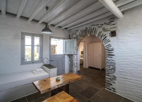 a living room with a table and a brick wall at Windmill Arades suite in Apollonia