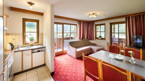 a kitchen and a living room with a table and a couch at Lärchenheim in Neustift im Stubaital