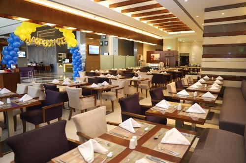 a dining room with tables and chairs and balloons at Golden Tulip Media Hotel in Dubai