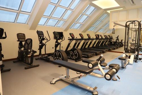 a gym with a row of treadms and machines at Golden Tulip Media Hotel in Dubai