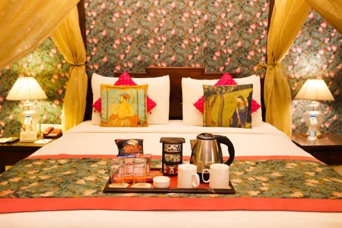 a hotel room with a bed with a tray of food at The Grand Imperial - Heritage Hotel in Agra
