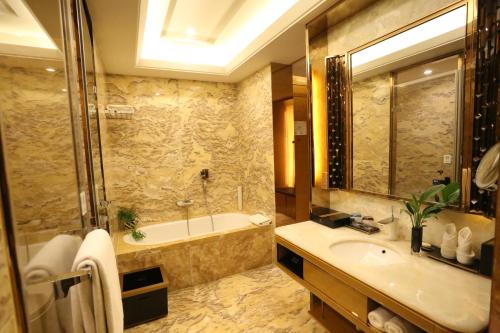 a bathroom with a tub and a sink at JinJiang International Hotel Urumqi in Ürümqi