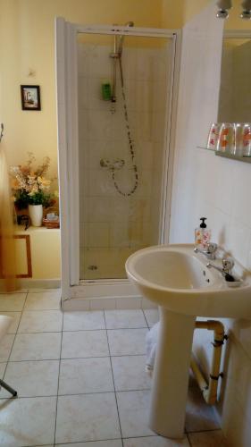 une salle de bain blanche avec une douche et un lavabo dans l'établissement Au Coeur de Rennes Chambres d'hôtes, à Rennes-les-Bains