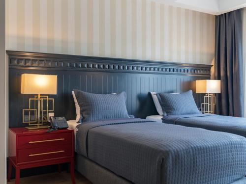 a hotel room with two beds and two lamps at Hotel Marina Bay Göcek in Göcek