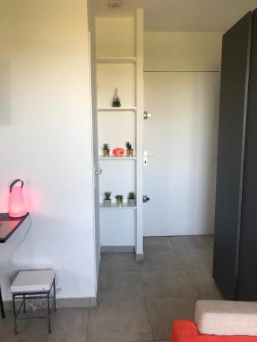 a room with white walls and a door with potted plants at LE MONICA in Narbonne